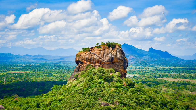 Superbe vue aérienne de la forteresse rocheuse de Sigiriya au Sri Lanka, entourée d'une végétation luxuriante et de montagnes.