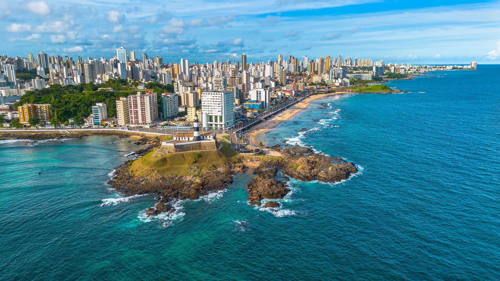 Une photo aérienne vibrante capturant la côte de Salvador, Bahia avec son horizon urbain et sa plage.