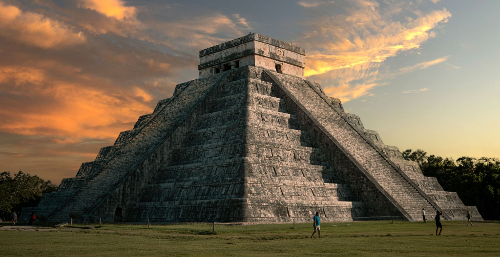 Vue majestueuse de la pyramide El Castillo à Chichen Itza avec un ciel de coucher de soleil vibrant.