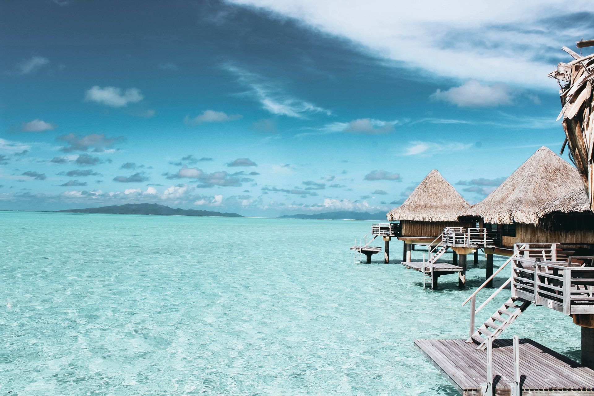 Des bungalows sur l'eau sur une mer turquoise cristalline en Polynésie française.