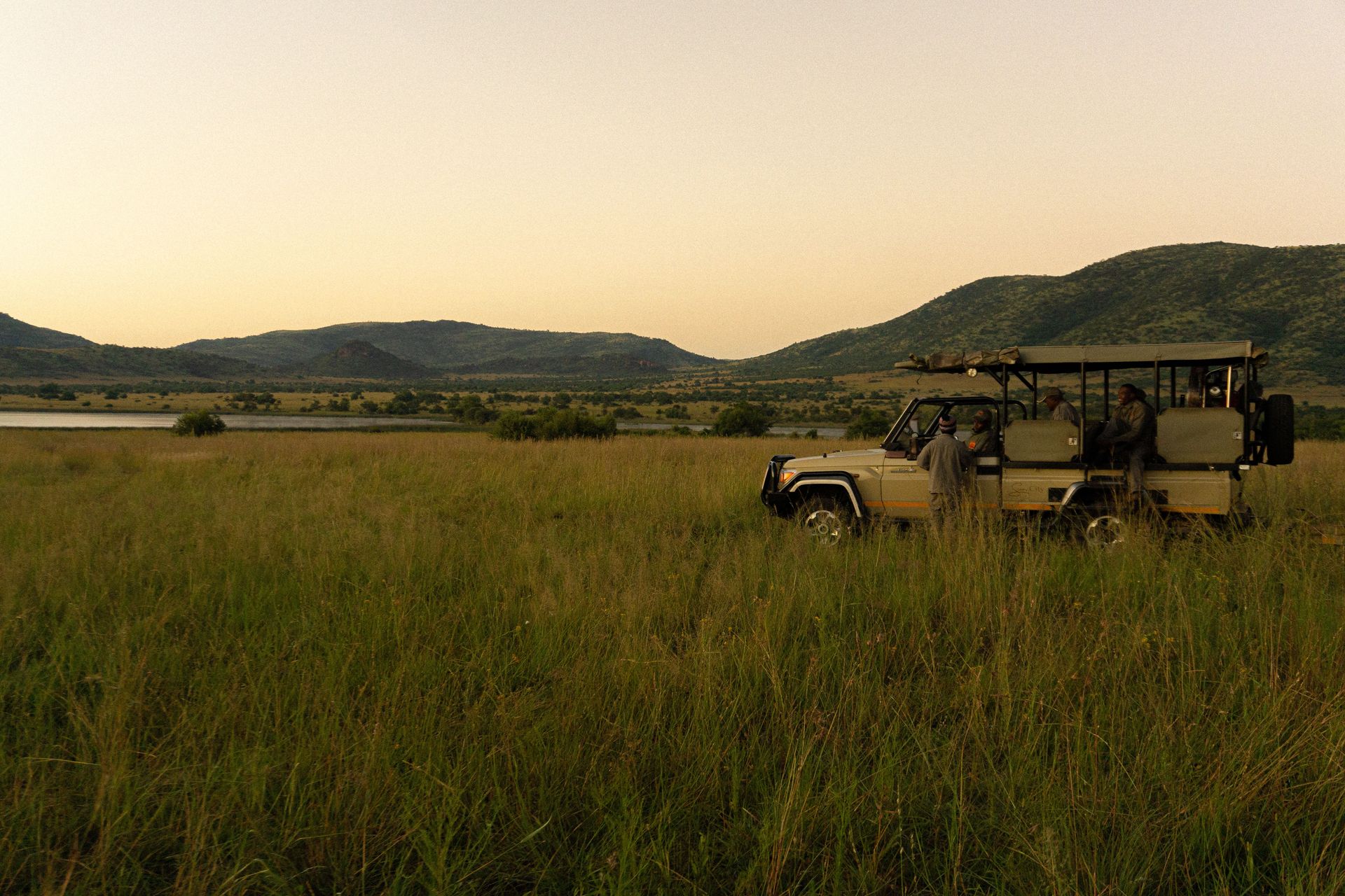 Un jeep safari avec des personnes observant la faune au crépuscule dans le parc national de Pilanesberg, Afrique du Sud.