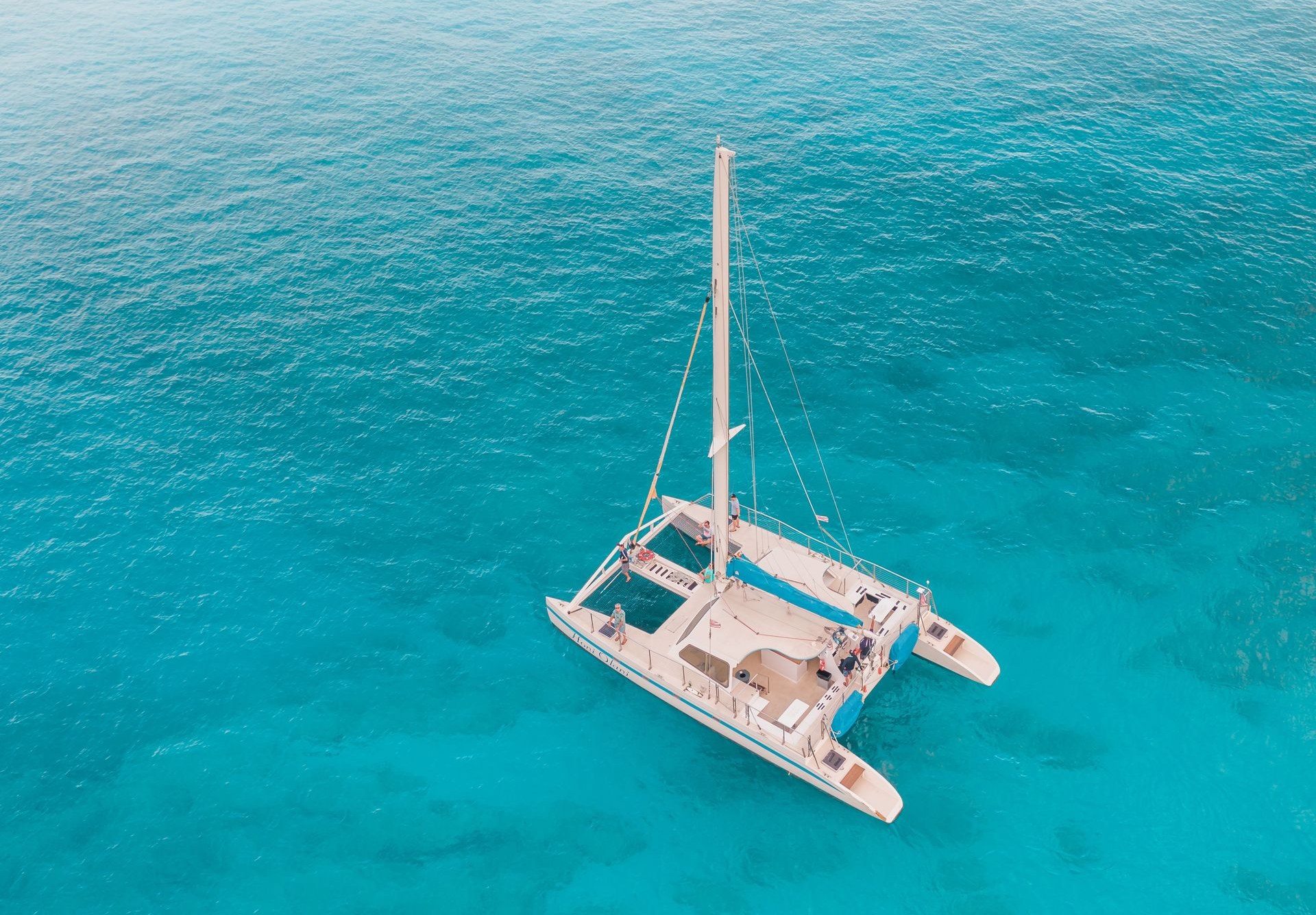 Superbe vue aérienne d'un catamaran naviguant dans des eaux turquoises cristallines.