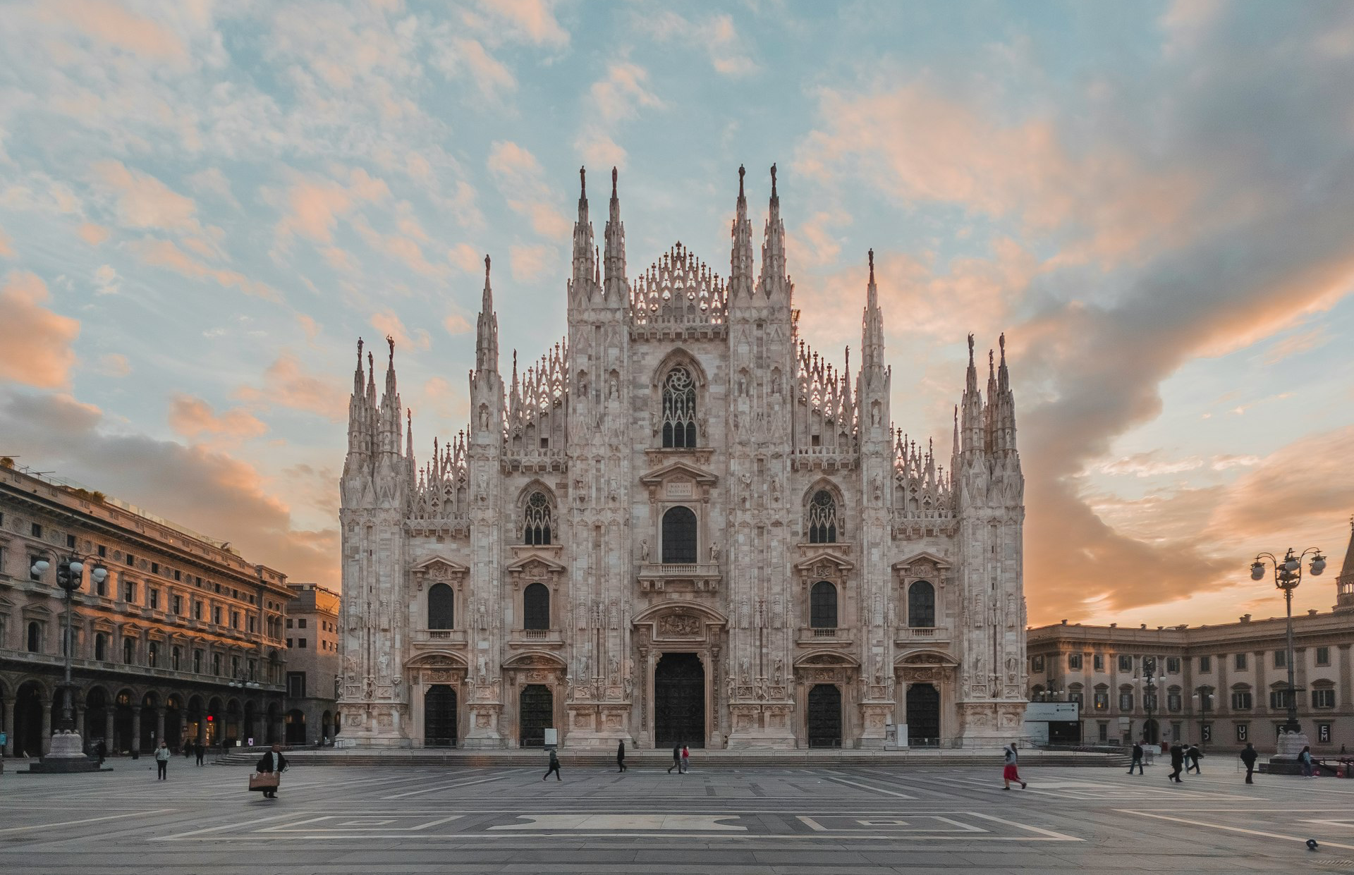 La cathédrale du Duomo de Milan à Milan, sous un ciel aux teintes douces orangées et bleues.