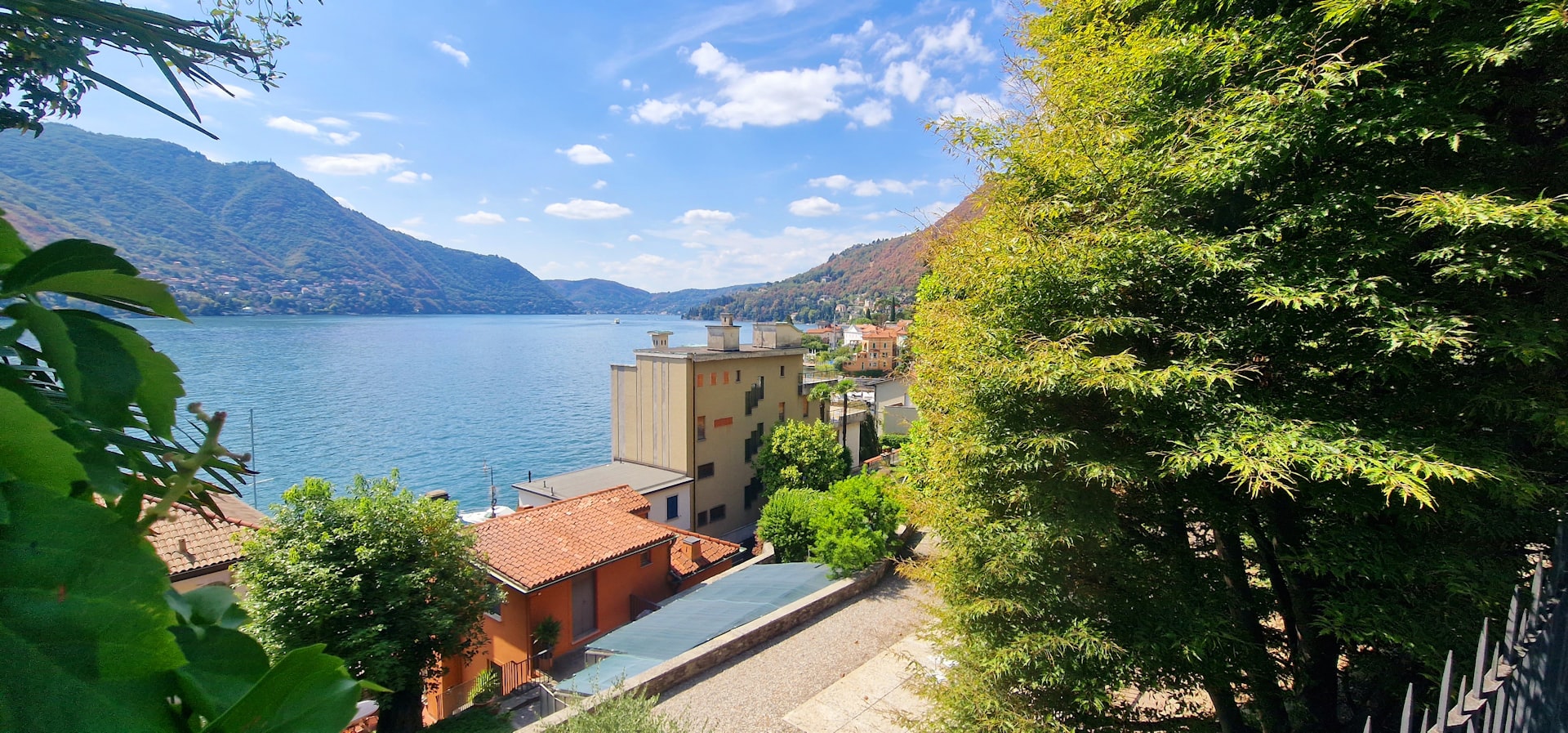 Étendue d’eau du lac de Côme en Italie entourée de bâtiments et d’arbres.