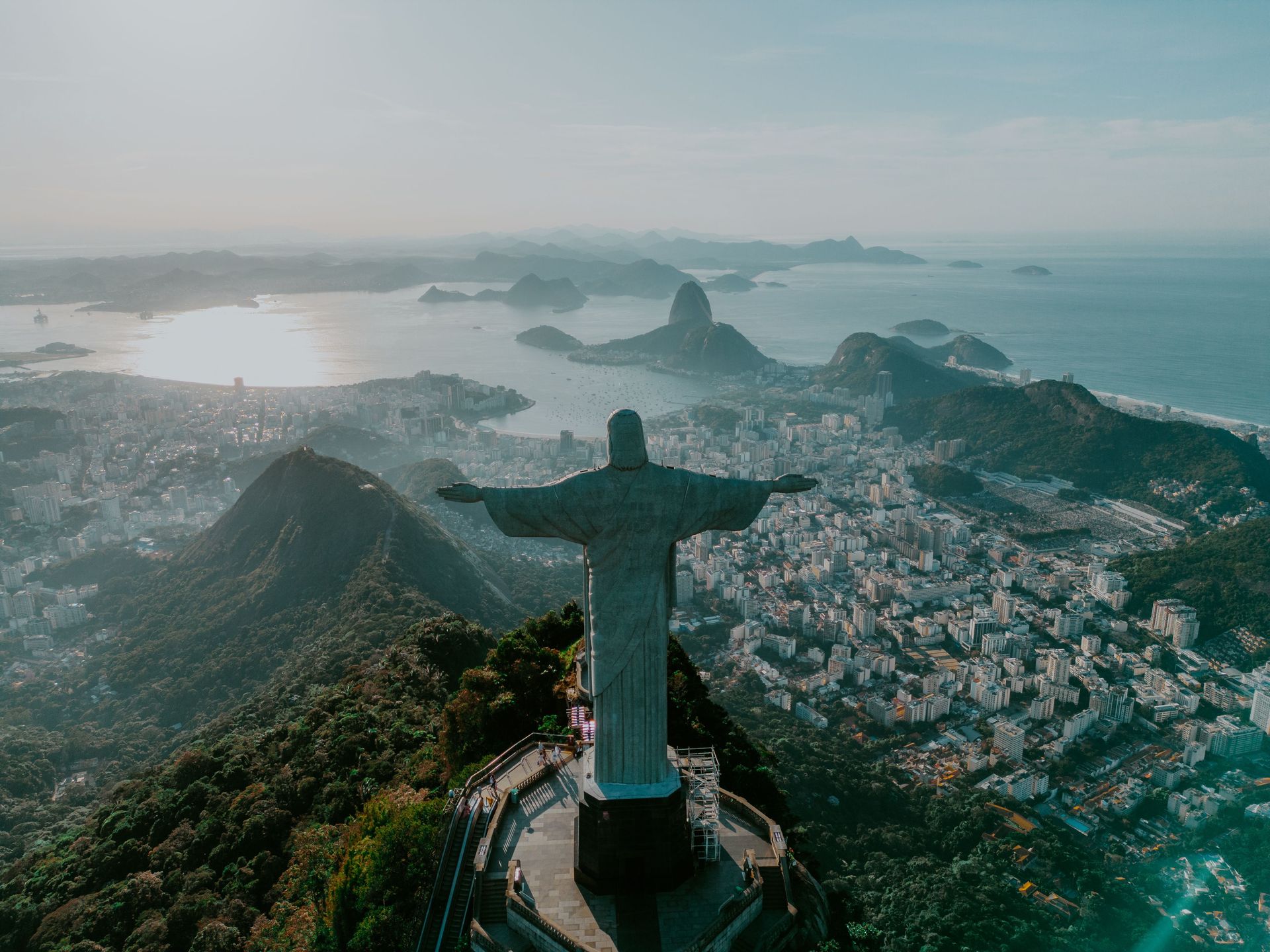 le Christ rédempteur vu du dessus, surplombant la ville de Rio. En arrière plan, un fleuve