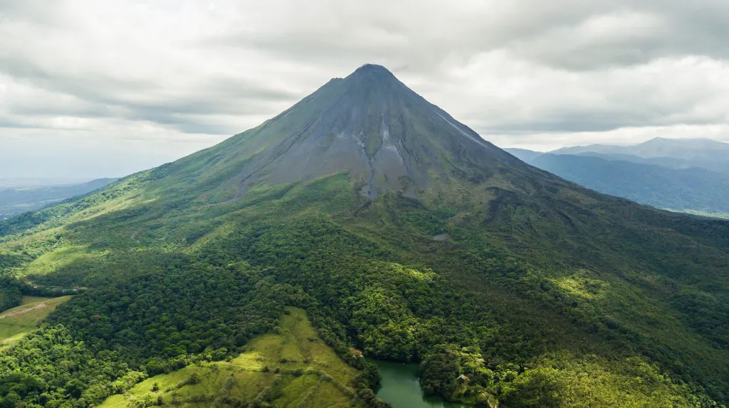 Vue aérienne dramatique du luxuriant volcan Arenal au Costa Rica contre un ciel nuageux.