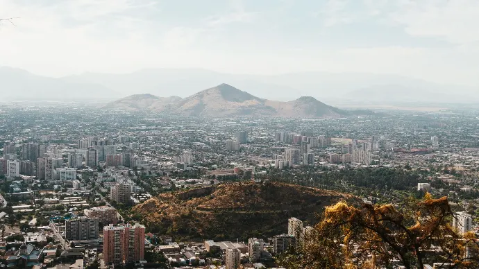 Vue aérienne de Santiago, Chili avec des montagnes en arrière-plan et le paysage urbain en dessous.