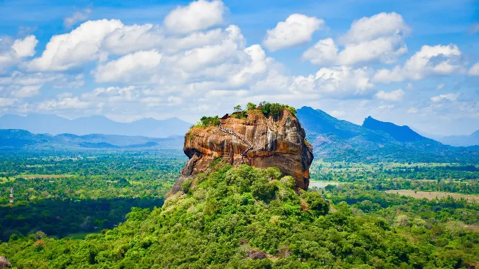 Superbe vue aérienne de la forteresse rocheuse de Sigiriya au Sri Lanka, entourée d'une végétation luxuriante et de montagnes.