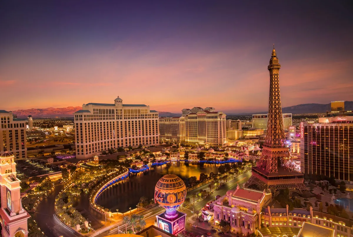 Vue aérienne époustouflante du Strip de Las Vegas au coucher de soleil avec la réplique emblématique de la Tour Eiffel et un paysage urbain vibrant.