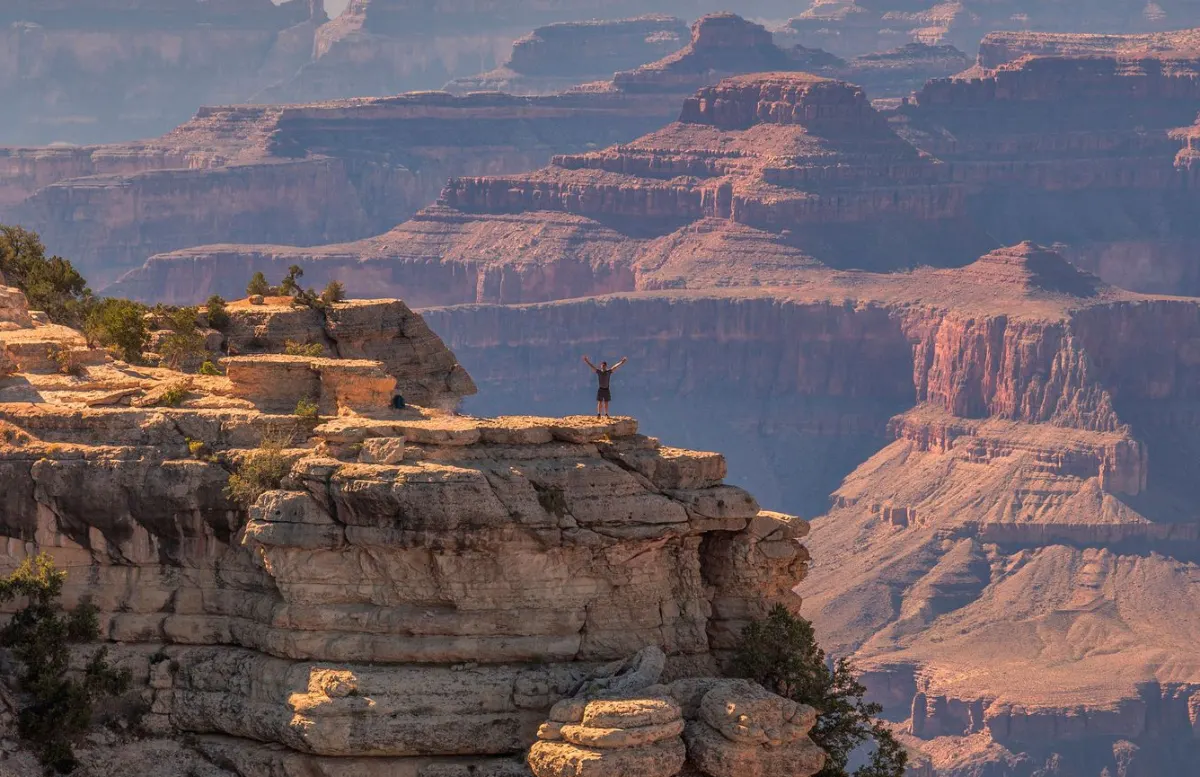 personne se tenant au bord du grand canyon