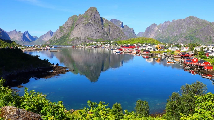 Vur panoramique d'un lac avec un village sur la rive et une montagne en fond